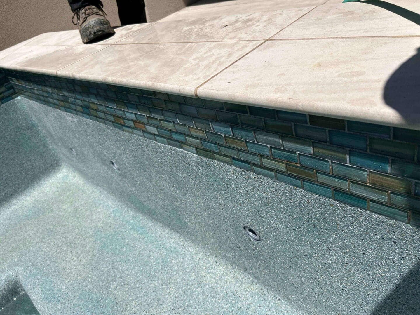 Empty swimming pool with tiled edge detail.