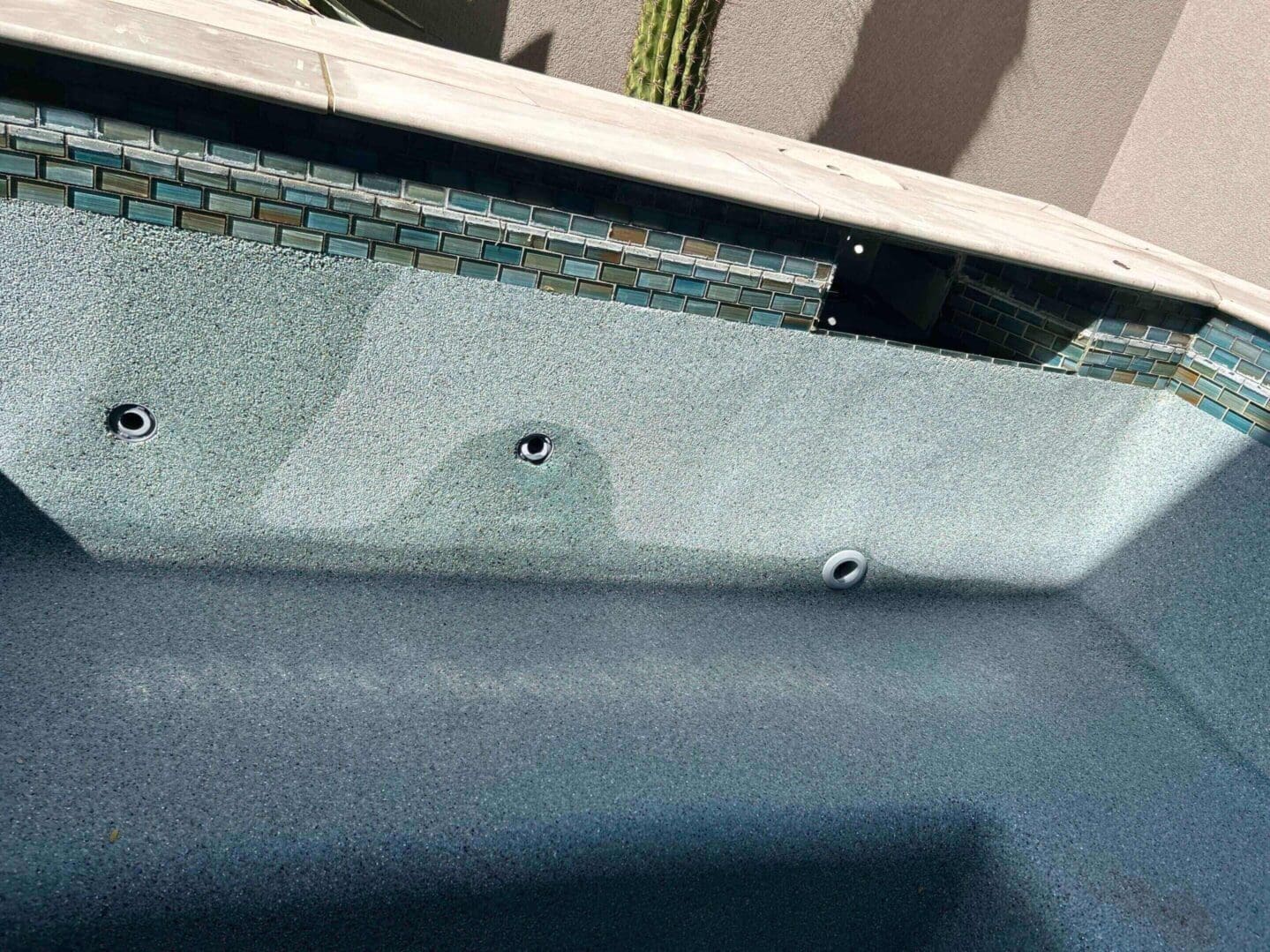 Empty swimming pool with mosaic tile border.