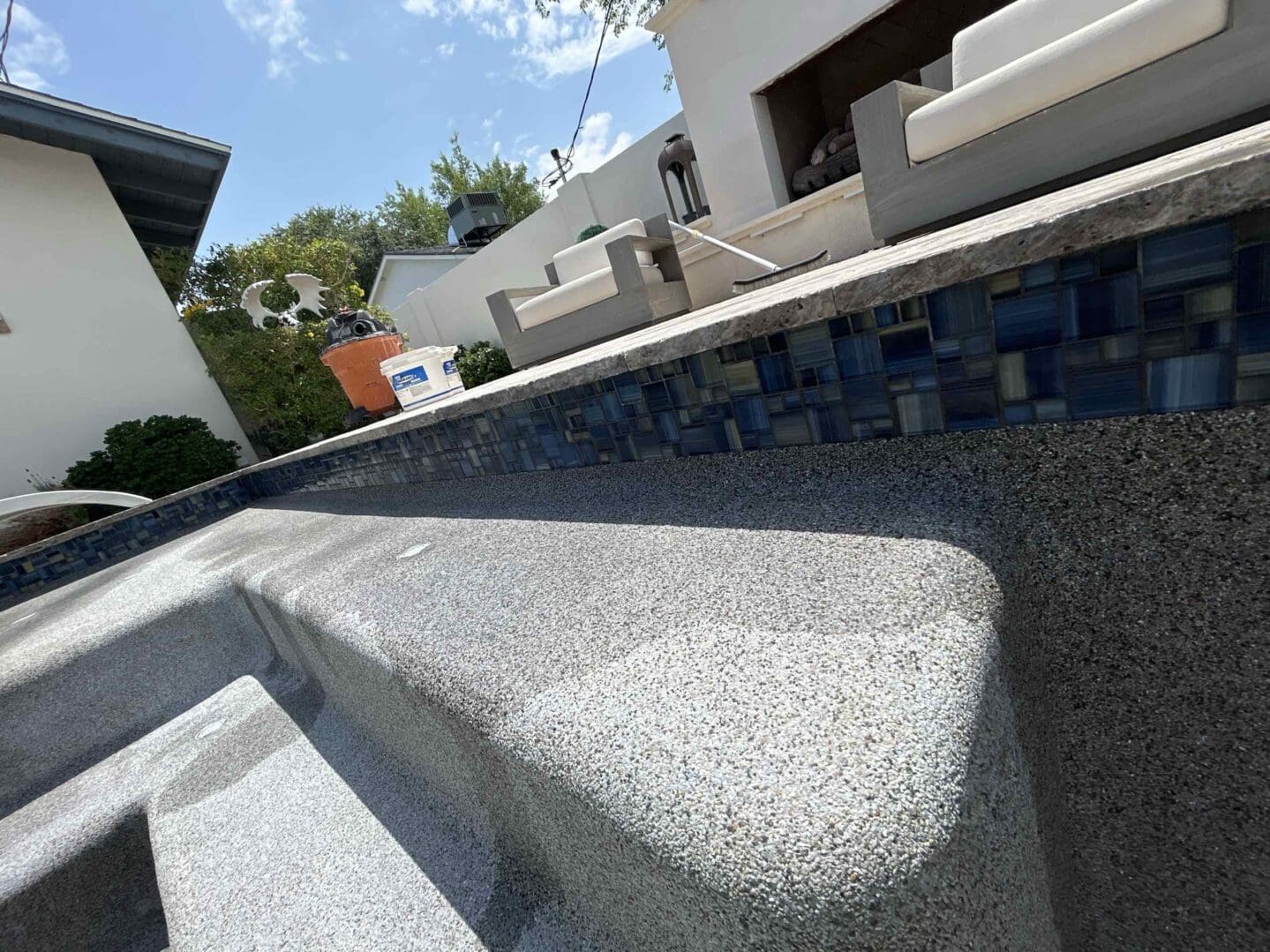Empty swimming pool with patio furniture.